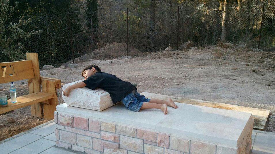 Yom HaZikaron: the touching photograph of the boy hugging his father's grave
